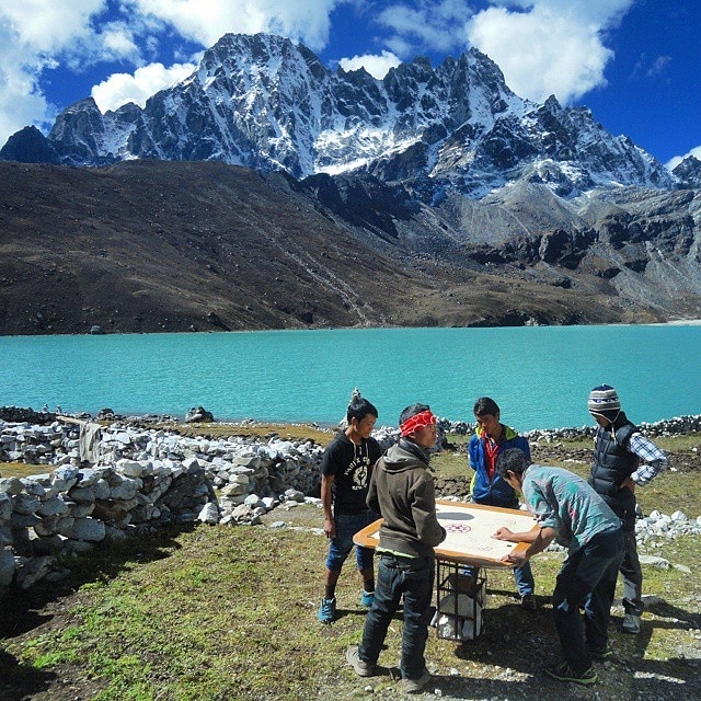 Playing Carrom by a Tranquil Lake with Mountain Views