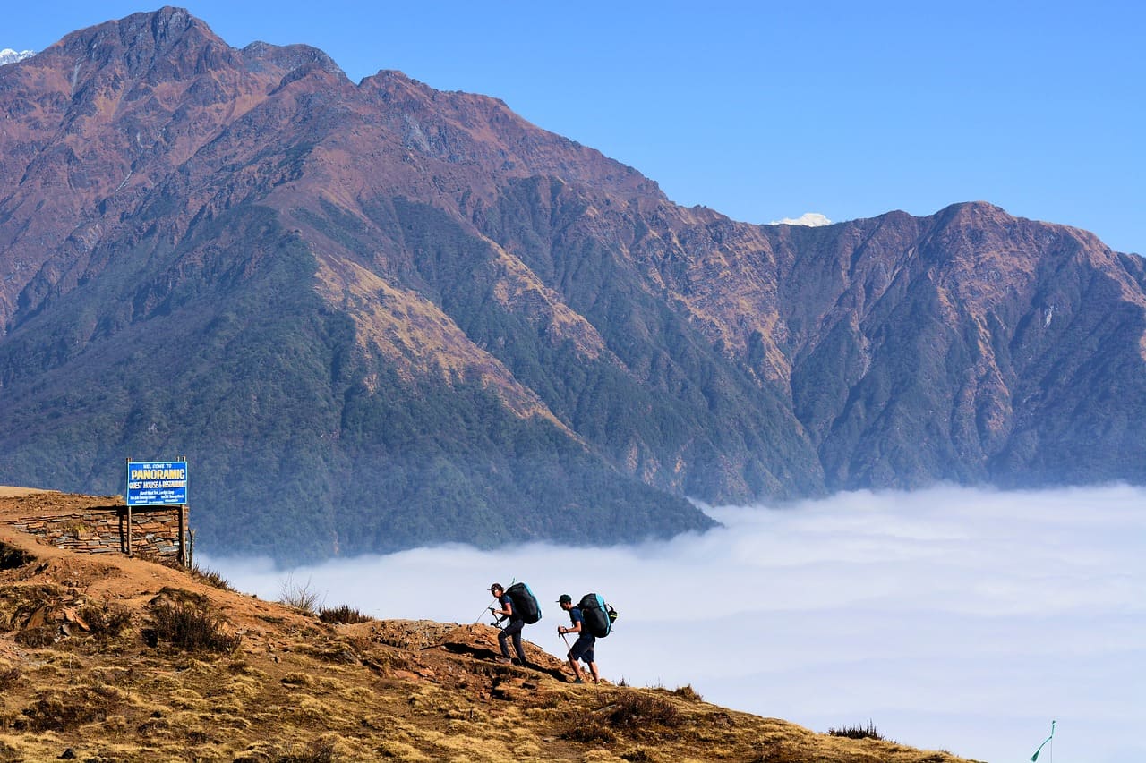 Trekkers walking higher than fog
