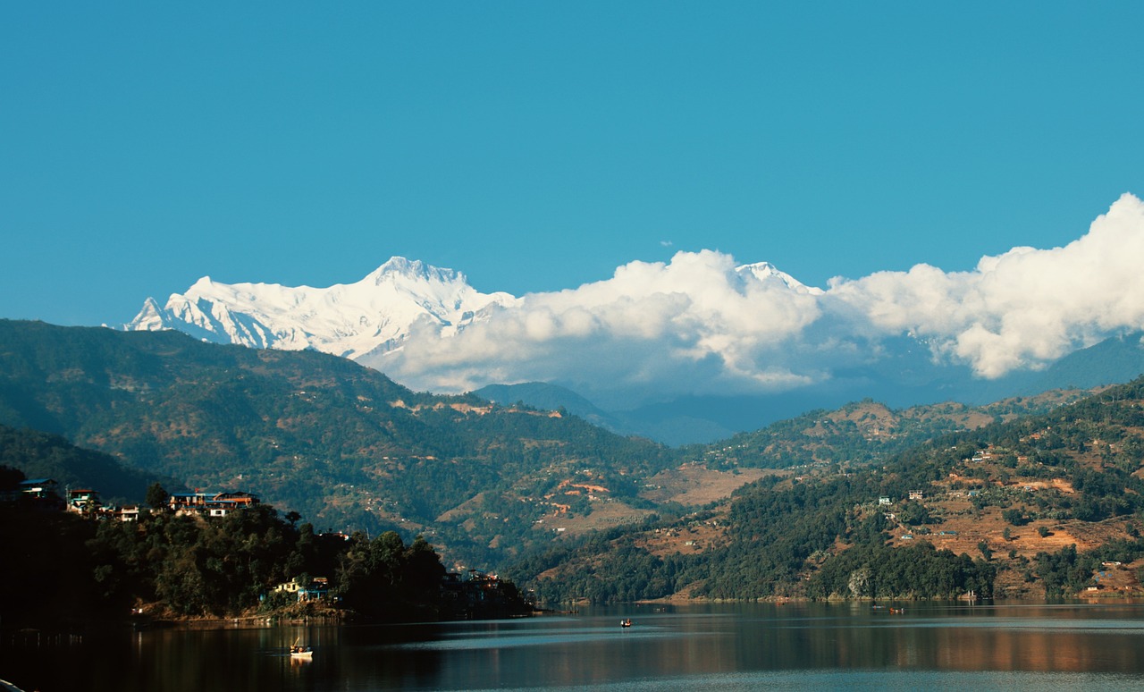Serene Lake with Hills, Clouds, and Majestic Mountains